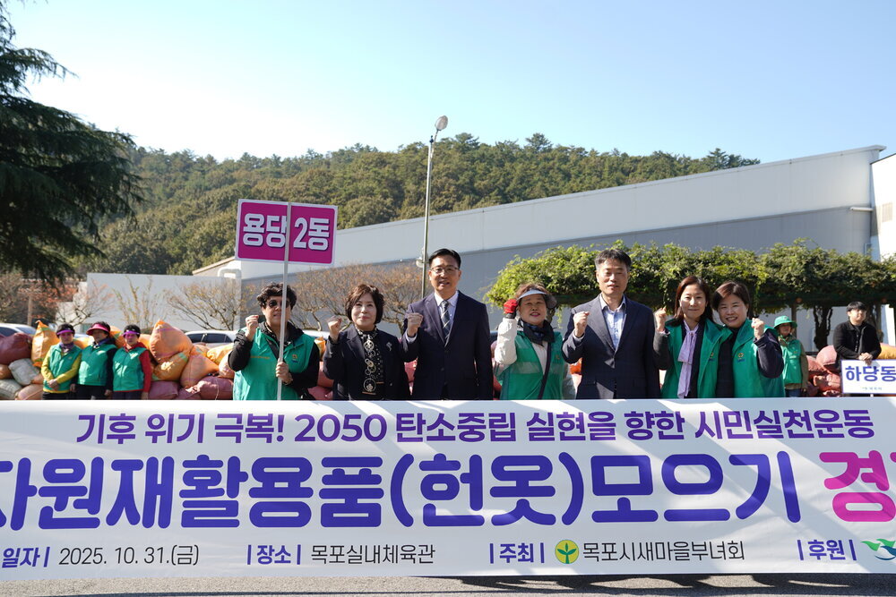 '자원재활용품(헌옷) 모으기 경진대회' 현수막 앞에서 '용당2동' 표지판을 들고 파이팅 포즈를 취하고 있는 목포시 관계자와 시민들.