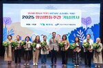 기념행사에서 수상자들이 패와 꽃다발을 들고 관계자와 함께 단체 기념 촬영을 하고 있는 모습이다.